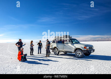 Salar de Uyuni, Bolivie, Uyuni : les touristes à pied en sel blanc appartements et profiter d'activités excursion en Jeep à travers le désert de sel bolivien Banque D'Images