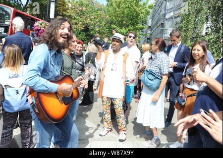 Abbey Road, NW8, London, UK, 8 août 2019. Un Beatles musicien ambulant divertit les fans alors qu'ils célèbrent le 50e anniversaire de l'album Beatles Abbey Road. Crédit : David Bronstein/Alamy Live News Banque D'Images