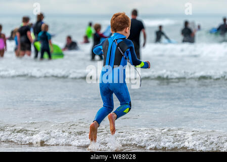 Bude, Cornwall, Angleterre du Nord. Jeudi 8 août 2019. Météo britannique. Avec le temps orageux imminente prévue pour plus tard aujourd'hui, les vacanciers profiter du soleil et du surf sur la plage de Bude Cornouailles du Nord. Credit : Terry Mathews/Alamy Live News Banque D'Images