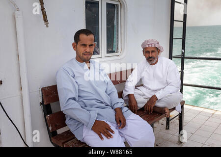 Deux passagers de sexe masculin en vêtements traditionnels on car ferry à l'île de Masirah, Oman Banque D'Images