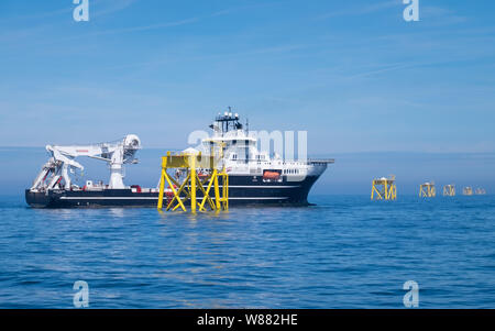 East Anglia un parc éolien offshore au cours de la construction avec le navire de soutien de la construction, Grand Canyon, travaillant sur les câbles sous-marins à proximité de l'une des installations éoliennes jacket Banque D'Images