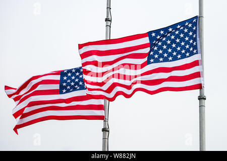 2 USA Les drapeaux sur mâts de drapeau qui flotte dans le vent Banque D'Images