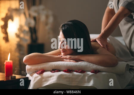 Spa, massage. Jeune fille belle brune se faisant masser. Banque D'Images