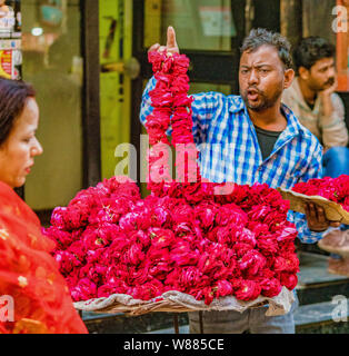 Vrindavan, Inde - 22 février 2018 - l'homme vend des fleurs fraîches rouge de sa table de rues Banque D'Images