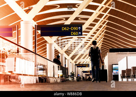 SHANGHAI, CHINE - DEC 2019 : meilleur avec un sac de voyage ou de bagages balade dans le terminal de l'aéroport de ronde pour voyageurs Banque D'Images