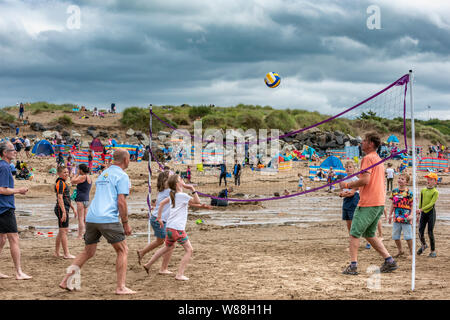 Bude, Cornwall, Angleterre du Nord. Jeudi 8 août 2019. Météo britannique. Avec le temps orageux imminente prévue pour plus tard aujourd'hui, les vacanciers faire une partie de beach-volley comme les nuages recueillir plus de Bude Cornouailles du Nord. Credit : Terry Mathews/Alamy Live News Banque D'Images