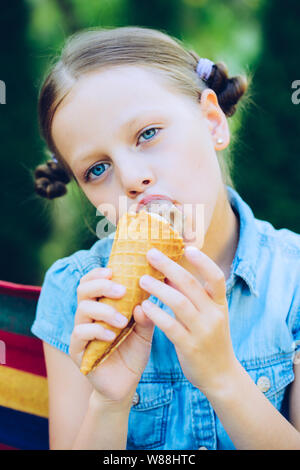 Smiling little girl eating ice cream Banque D'Images