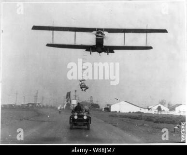 Freddie sans peur, un cascadeur d'Hollywood, accroché à une échelle de corde suspendue à partir d'un avion piloté par H Maltrup, sur le point de tomber dans l'automobile automobile montré ci-dessous : Banque D'Images