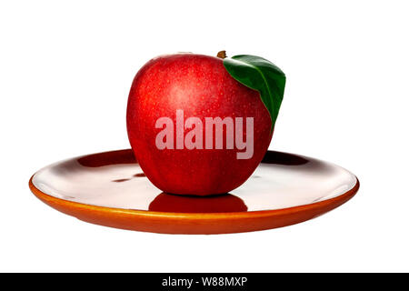 Pomme Rouge posé sur une plaque d'argile. En position sur un fond blanc. Isoler Banque D'Images
