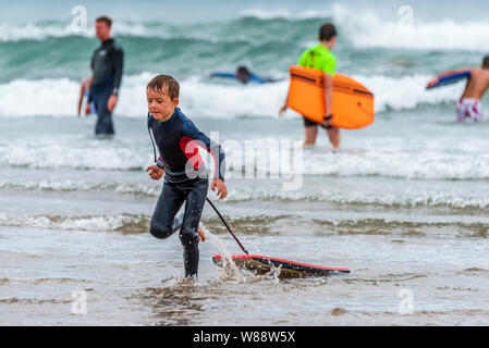 Bude, Cornwall, Angleterre du Nord. Jeudi 8 août 2019. Météo britannique. Avec le temps orageux imminente prévue pour plus tard aujourd'hui, les vacanciers profiter du soleil et du surf sur la plage de Bude Cornouailles du Nord. Credit : Terry Mathews/Alamy Live News Banque D'Images