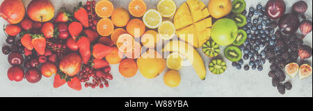 Petits fruits Fruits arc-en-ciel sur fond blanc. Vue de dessus de bleuets fraises mangue cerises citrons oranges pommes prunes mûres, groseilles rouges Banque D'Images