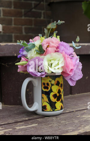 Fleurs Bouquet de lisianthus multicolores dans une tasse avec des pensées Banque D'Images