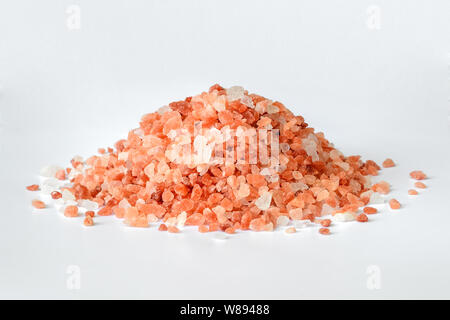 Tas de cristaux de sel de l'himalaya rose sur fond blanc. Sel de l'Himalaya est utilisé en cuisine, en médecine et en cosmétologie. Vue de face. Banque D'Images