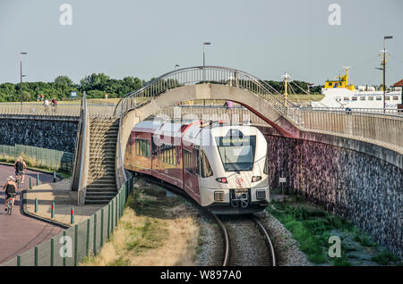 Harlingen, Pays-Bas, le 26 juillet 2019 : un train local sur une piste le long de la paroi de la mer vers le port de railay Banque D'Images