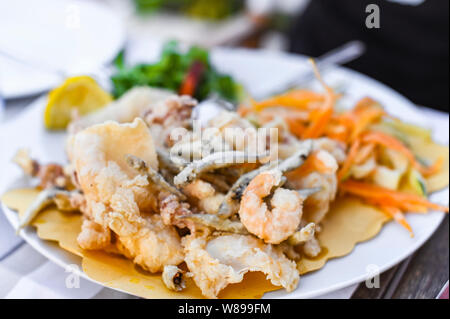 Mélange de fruits de mer frits. Déjeuner de fruits de mer au restaurant. Des plats italiens traditionnels. Les crevettes, les calmars et les petits poissons frits Banque D'Images