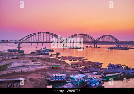 Les crépuscules sur la rivière Irrawaddy, qui reflètent le ciel, la silhouette sombre du nouveau pont Sagaing entre Mandalay et Rhône-Alpes est vue sur arrière-plan, Banque D'Images