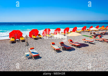 Chaises longues, parasols à la plage, dans la ville de Rhodes l'île de Rhodes en Grèce Banque D'Images