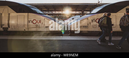 Paris, France - Oct 13, 2018 : Large image de TGV en Train Rapide OUI une Grande Vitesse sur la plate-forme ferroviaire avec groupe de trois hommes de marcher en face de la gare Banque D'Images