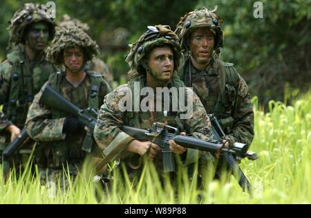 Les Marines américains se déplacent à travers la couverture végétale dense à la périphérie d'une ville occupée par les forces de l'opposition simulée à Schofield Barracks, Missouri, le 20 juillet 2004. Les marines participent à des opérations militaires sur un terrain urbanisé de l'évolution de la formation à l'appui de l'exercice Pacific '04. L'exercice Rim of the Pacific '04 est un exercice maritime international conçu pour améliorer la performance tactique de la participation du littoral du Pacifique y compris les participants de l'Australie, Canada, Chili, Japon, Corée du Sud, le Royaume-Uni, les États-Unis et les Marines sont affectés à la 3e Batt Banque D'Images