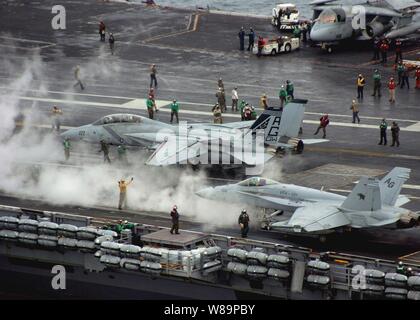 Un F-14B Tomcat (à gauche) et un F/A-18C Hornet (droite) sont préparées pour lancer à partir de l'envol du porte-avions USS George Washington (CVN 73) tel qu'il fonctionne dans l'Océan Atlantique le 20 octobre 2004. Washington mène le groupe soutien la formation au large de la côte est des États-Unis. Le Tomcat est affecté à l'Escadron de chasse 143 et le frelon est attribué à Fighter Attack Squadron 131. Banque D'Images