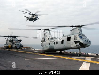 Deux U.S. Marine CH-53E Super Etalons et un CH-46 Sea Knight (droite) se préparent pour le transport des marines depuis la cabine de pilotage de l'USS Kearsarge (DG 3) à Onslow Bay, N.C., pour un exercice d'assaut de la plage, le 22 novembre 2004. Le groupe expéditionnaire Kearsarge et la 26e unité expéditionnaire de Marines embarqués sont chargés de l'instruction intégrée en vue d'un déploiement prévu. Banque D'Images