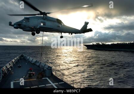 Un hélicoptère SH-60 Seahawk ramasse la cargaison de l'envol de l'USS Ford (FFG 54) au cours d'une opération de ravitaillement vertical avec le porte-avions USS JOHN C. STENNIS (CVN 74) Le 18 octobre 2004. La Ford et son hélicoptère ci-joint l'Escadron anti-sous-marines sont 49 sur un déploiement avec le Stennis strike group. Banque D'Images