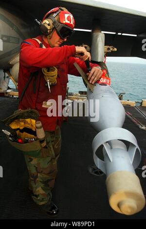 Maître de 3e classe Joshua Silva attache un stabilisateur d'une GBU-16 fin Paveway II 1 000 livres de bombes guidées au laser chargé sur un F/A-18C Hornet à bord du porte-avions USS Harry S. Truman (CVN 75) en cours dans le golfe Persique, le 19 novembre 2004. Silva est un ordnanceman aviation affectés à 105 e Escadron d'avions. Banque D'Images