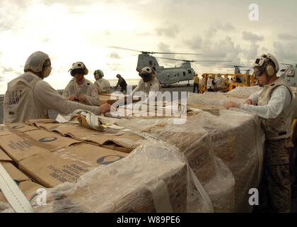 Les Marines américains affectés à la lutte contre la Division du fret à bord d'USS Bonhomme Richard (DG 6) préparer les palettes de repas conditionnés prêts-à-manger pour livraison aux régions touchées par le tsunami de l'Indonésie au 6 janvier 2005. Des hélicoptères de Richard et de marins et soldats affectés à 5 groupe expéditionnaire fournissent une aide humanitaire aux régions dévastées par le 26 décembre, 2004, de l'Océan indien dans le cadre de l'opération Unified Assistance. Banque D'Images