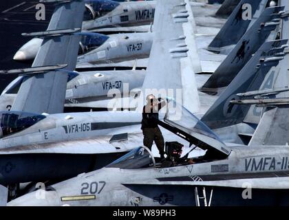 Le Cpl Marine. Rodger Lagrange nettoie l'auvent d'une aire marine de F/A-18A Hornet + à bord de l'USS Harry S. Truman (CVN 75) tandis que le porte-avions opère en mer le 14 février 2005. La grève de Truman et Groupe Carrier Air Wing 3 mènent l'appui aérien rapproché, renseignement, surveillance, et des missions de reconnaissance au-dessus de l'Iraq. Lagrange est joint à Marine Fighter Attack Squadron 115 déployés à partir de Marine Corps Air Station Beaufort, L.C. Banque D'Images