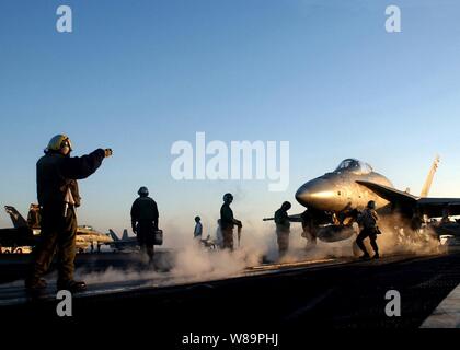 Marins et soldats de la Marine américaine effectuer les dernières vérifications avant le lancement d'un F/A-18A Hornet d'un des quatre catapultes à vapeur sur le pont d'envol du porte-avions USS Harry S. Truman (CVN 75) sur le 24 janvier 2005. Truman et entrepris Carrier Air Wing 3 fournissent un appui aérien rapproché et la réalisation d'intelligence, de missions de surveillance et de reconnaissance au-dessus de l'Iraq. Le Frelon est affecté à l'escadron de combat interarmées Marine 115. Banque D'Images