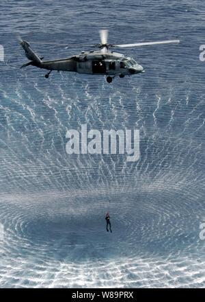 Le souffle du rotor d'un MH-60 de la Marine américaine Knight Hawk hélicoptère est un modèle dans la mer Méditerranée qu'il monte un nageur de recherche et de sauvetage au cours des exercices le 19 avril 2005. Les nageurs et les équipages de l'hélicoptère d'attaque USS Kearsarge gardent leurs compétences grâce à la formation de sauvetage lors d'un déploiement à l'appui de la guerre contre le terrorisme. Banque D'Images