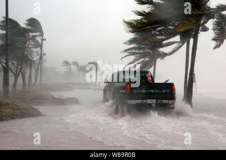 Une équipe de sécurité Marine facilite leur chemin à travers l'eau et les débris à l'Annexe Truman Naval Air Station de Key West, en Floride, que l'ouragan Dennis passe le plus au sud de la base le 9 juillet 2005. La tempête est passé à moins de 125 kilomètres de la base, avec des vents de plus de 90 milles à l'heure et de dumping plus de sept pouces de pluie avant de passer au nord par le golfe du Mexique. Banque D'Images