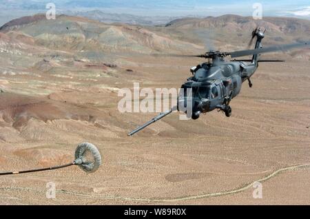 Un U.S. Air Force HH-60H Pave Hawk helicopter s'approche d'un panier de ravitaillement comme il se prépare à se ravitailler en vol à partir d'un SC-130 Hercules lors d'un exercice d'entraînement de sauvetage du désert plus de FALLON, Nevada, le 14 juillet 2005. Sauvetage du désert est un multi-service, de l'exercice de formation pour préparer les équipes de recherche et sauvetage de combat d'extraire du personnel au sol dans une variété d'environnements et de situations. Banque D'Images