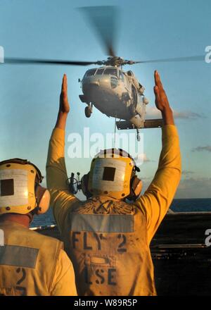 Manœuvriers Aviation aviateur Mate Manuel Romero (droite) guides un SH-60 Seahawk pour un atterrissage en hélicoptère à bord du USS Tarawa (LHA 1) tandis que maîtres d'aviation Mate 2e classe David Zavala regarde pendant les opérations de ravitaillement vertical au large de la côte de San Diego, Californie, le 22 septembre, 2005. Banque D'Images