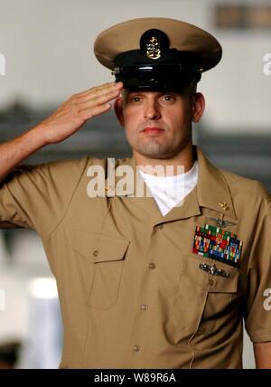 Épinglé récemment le Premier maître de la Marine américaine John Vincent salue comme il marche par sideboys de cérémonie lors d'un premier maître de cérémonie l'épinglage dans le hangar Bay de l'USS Harry S. Truman (CVN 75) dans le golfe du Mexique le 16 septembre 2005. Les 47 nouvelles de l'premiers maîtres Truman faisaient partie de plus de 5 000 dans le monde qui poursuivent le 112-year-old Tradition d'entrée dans la Marine a engagé des rangs. Banque D'Images