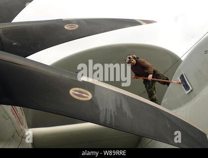 Un aviateur de la Marine américaine scrubs le fuselage d'un E-2C Hawkeye sur le pont du porte-avions USS Enterprise (CVN 65) comme le navire opère dans l'Océan Atlantique le 3 mars 2006. L'entreprise et son escadre aérienne de transporteur 1 sont la réalisation d'une unité de formation composite exercice en mer. Le Hawkeye, jointe à la Force aéroportée de détection lointaine de l'opérateur, l'Escadron 123 de la Marine est en tout temps, de porte-avions de combat tactique aéroporté de détection lointaine de gestion, de commandement et de contrôle de l'avion. Banque D'Images