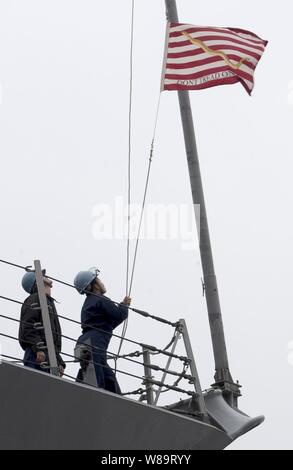 Marins sur la mer et d'abaisser le détail comme le Jack Navy destroyer lance-missiles USS Curtis Wilbur (DDG 54) se met en route de Yokosuka, Japon, le 19 avril 2006. Marine Le cric a été voler sur tous les navires de la marine américaine depuis le 11 septembre 2001, d'honorer ceux qui sont morts ce jour-là. Banque D'Images