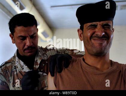 Un soldat de l'armée iraquienne grimace en tant qu'infirmier de l'armée iraquienne vaccine lors d'une vaccination de masse pour le tétanos, la typhoïde et la méningite à Camp Taji, l'Iraq, le 1 mai 2006. Les soldats sont d'Iraqís 9e division mécanisée. Banque D'Images