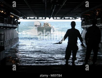 Guide les marins de la marine américaine de débarquement d'un bateau dans l'utilitaire bien inondées pont de l'USS Kearsarge (DG 3) pour décharger du matériel et des fournitures que le navire opère dans l'Océan Atlantique le 15 août 2006. Le navire d'assaut amphibie participe à l'exercice Panamax '06, un exercice multinational, impliquant les États-Unis, pays d'Amérique centrale et du Sud, et des Caraïbes. Banque D'Images