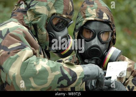 La Marine américaine Maître de 2e classe Ian Jordan (à gauche) et le lieutenant J.G. Eric Hui exécuter des tests sur les substances chimiques soupçonnées au cours d'un exercice de guerre à Fort Story, Va., Octobre 27, 2006. Le scénario fait partie de l'élimination des explosifs et munitions Top-Tech Challenge 2006 qui se tient au Fort Story. La Jordanie et l'Hui sont des techniciens des explosifs et munitions de la marine à partir de la neutralisation des explosifs et de l'Unité Mobile 2, Virginia Beach, en Virginie. Banque D'Images