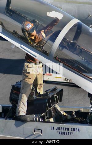 Un avion de la Marine Le capitaine de l'escadron de combat interarmées 195 nettoie l'intérieur de la canopée d'un F/A-18F Super Hornet avant les opérations de vol à bord de l'USS Kitty Hawk (CV 63) le 26 octobre, 2006. Le Kitty Hawk, opérant à partir des activités liées à la flotte de Yokosuka, Japon, fonctionne au large de la côte sud du Japon. Banque D'Images