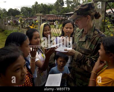 Le capitaine de l'Armée Américaine Natalie Wendling autographes kid's local médical à un portables programme d'action civique lors de l'exercice Balikatan 2007 à Lanao del Norte, République des Philippines, le 23 février 2007. Balikatan 2007 met l'accent sur l'interopérabilité des forces et les opérations d'aide humanitaire / civique. Wendling est des services vétérinaires, Misawa Air Base, le Japon. Banque D'Images