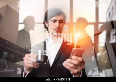 Businessman travaille avec son smartphone dans bureau. double exposition. Banque D'Images