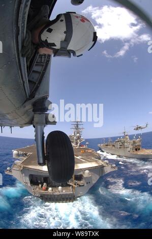 La Marine américaine Maître de 2e classe David Rankin se penche hors de la porte d'un SH-60 Sea Hawk, alors que l'hélicoptère s'approche de la cabine de pilotage du porte-avions USS Ronald Reagan (CVN 76) au cours de l'exploitation en mer de Chine du Sud le 6 avril 2007. Le groupe aéronaval du Ronald Reagan est en cours dans l'océan Pacifique sur un déploiement de surtension à l'appui des opérations militaires des États-Unis dans le Pacifique occidental. Rankin est joint à l'Escadron d'hélicoptères de lutte anti-sous-marine 4. Banque D'Images