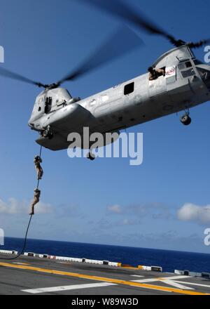 Les Marines américains affectés à Marine Expeditionary Unit 22 Faites glisser à partir d'un CH-46E Sea Knight hélicoptère pour le poste de pilotage de l'assaut amphibie USS Kearsarge LHD (3) pendant un exercice de corde rapide dans l'Océan Atlantique du 8 aout 2007. Banque D'Images