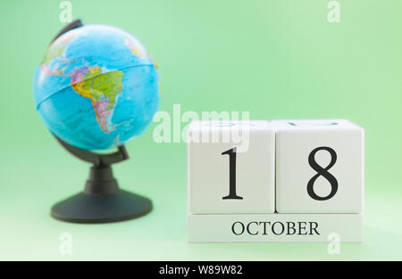 Calendrier en bois sur un fond vert clair, 18 jour du mois d'octobre, 18e jour de l'automne Banque D'Images