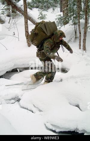 Un étudiant à la Marine de survie, évasion, résistance et s'échapper à travers une école raquettes ruisseau gelé pendant la formation dans Rangely, Maine, le 3 février 2008. Banque D'Images