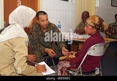 Le lieutenant de la marine américaine Thomas Hoang (2e de gauche) parle d'un patient des soins médicaux et dentaires au cours d'une action civique en projet, l'Indonésie, Jangkar Puskesmas le 12 mars 2008. Les Marines américains et les marins de la 31e unité expéditionnaire de Marines et les membres des forces armées indonésiennes sont l'exécution du projet d'accroître l'assistance humanitaire et les secours en cas de catastrophe la capacité d'intervention, améliorer l'interopérabilité et de poursuivre les relations professionnelles entre les deux armées. Banque D'Images