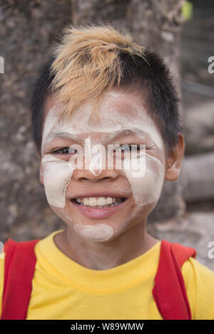 Un jeune garçon heureux avec le Birman traditionnel Thanaka maquillage sur qui est une pâte blanche de protection solaire et de modèle de cheveux actuelle à Bagan au Myanmar. Banque D'Images