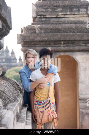 Une très bonne femme touriste et un jeune garçon birman avec le traditionnel Thanaka maquillage sur de vieux temple de Bagan Myanmar & femme libérée. Banque D'Images